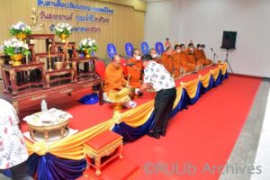 ภาพผู้ช่วยศาสตราจารย์วุฒิศักดิ์ ลาภเจริญทรัพย์ ประธานในพิธี ถวายผ้าบังสุกุลอุทิศส่วนกุศลให้แก่ผู้บริหาร และบุคลากรมหาวิทยาลัยรามคำแหงผู้ล่วงลับ
