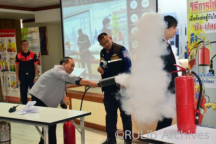 ภาพบุคลากรสำนักหอสมุดกลาง ฝึกใช้ถังดับเพลิงและทำความเข้าใจการทำงานของสารเคมีที่อยู่ในถังดับเพลิง