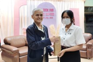 ภาพรองศาสตราจารย์สุขุม นวลสกุล มอบรางวัลแก่นักศึกษาที่ร่วมตอบคำถามได้ถูกต้อง