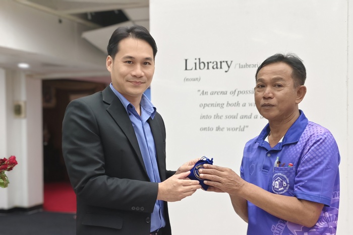 ภาพผู้อำนวยการสำนักหอสมุดกลาง มอบของขวัญแด่คุณมานพ ศรีถมยา